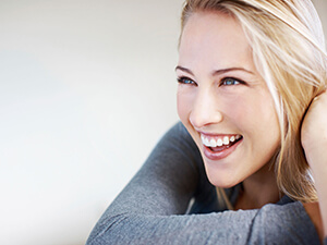 lady in gray sweater with big smile